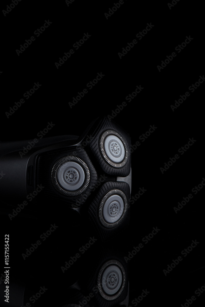 Closeup Image of 3 Blades Electric Shaver On Black Reflective Surface. Vertical image Composition Closeup Image of 3 Blades Electric Shaver On Black Reflective Surface. Vertical image Composition