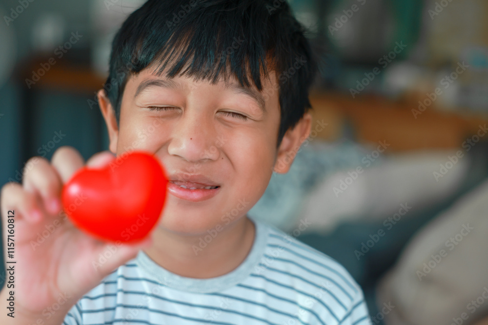 Happy Valentine's Day. The boy smile holds a red heart in his hand to give love to everyone. Mothers Day. Birthday. concept of Love, Care, family, health, Important days, and donation. Copy space. Happy Valentine's Day. The boy smile holds a red heart in his hand to give love to everyone. Mothers Day. Birthday. concept of Love, Care, family, health, Important days, and donation. Copy space.