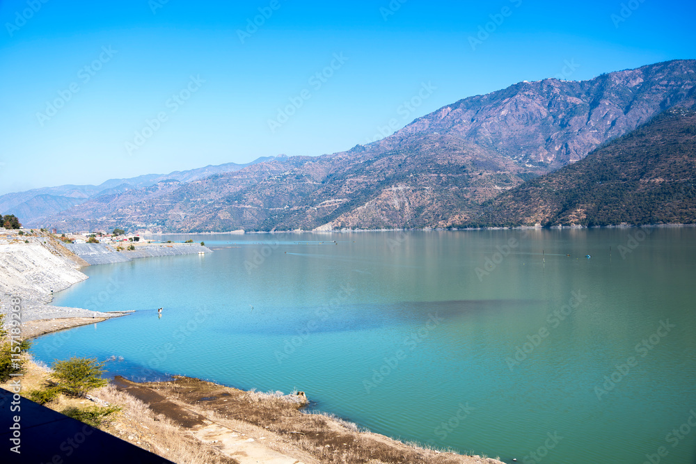 A wide view captures Tehri Lake, flanked by mountains on the sides. The natural beauty of the landscape offers a breathtaking sight for visitors. A wide view captures Tehri Lake, flanked by mountains on the sides. The natural beauty of the landscape offers a breathtaking sight for visitors.