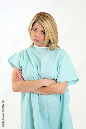 Sexy blonde woman in a hospital gown - arms crossed and appearing unhappy or sad