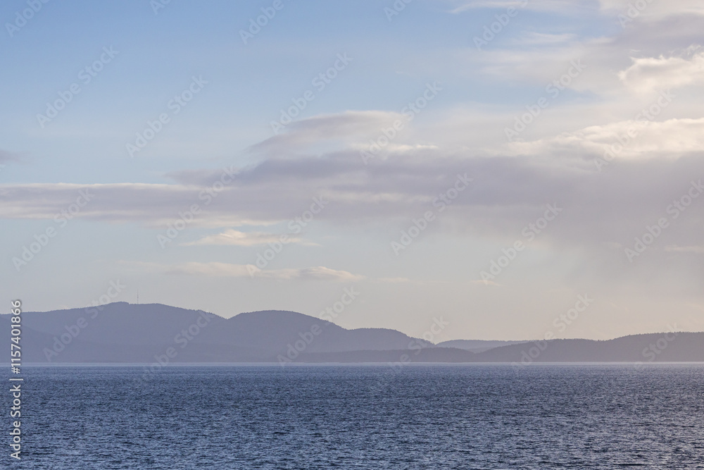 Scenic Ocean View With Distant Hills and Partly Cloudy Sky Scenic Ocean View With Distant Hills and Partly Cloudy Sky