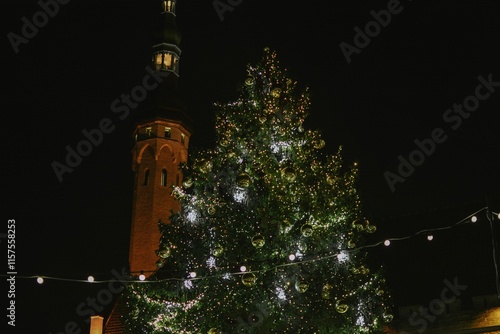 Christmas tree at christmas market at town hall of europe city decorated with lights at night photo