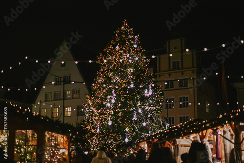 Christmas tree at christmas market at town hall of europe city decorated with lights at night photo