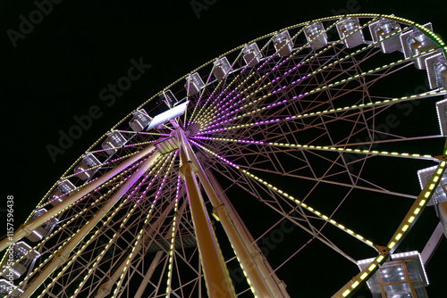 Glowing ferris wheel in the night, amusement park attraction