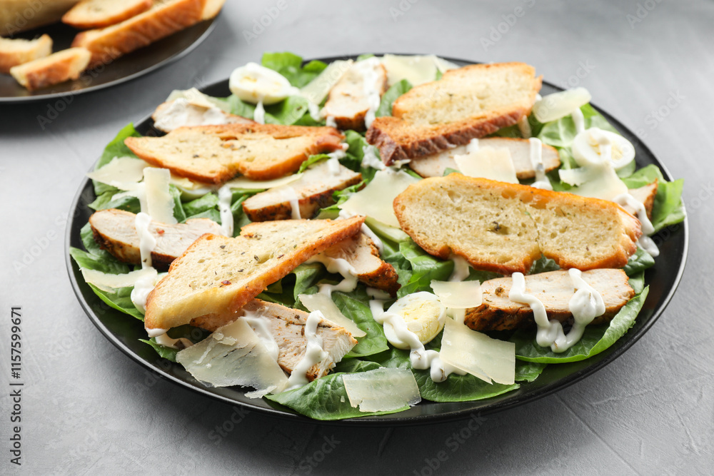 Delicious Caesar salad with chicken on grey textured table, closeup Delicious Caesar salad with chicken on grey textured table, closeup