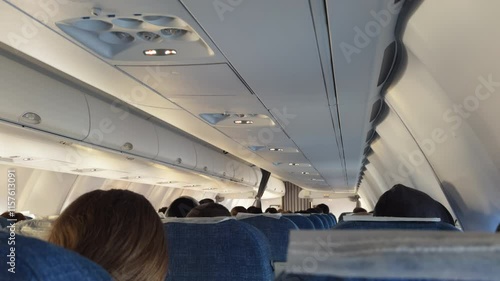 Pov of a passenger flying in passenger plane. Moment of flight in an airplane half-filled with people. View from inside large airliner with their seats and passengers sitting on them during daytime