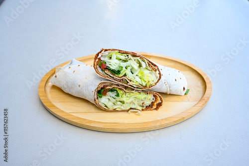 Cig kofte (raw meatball) with lettuce, tomato, pickle and lemon, hot Chee kofta. Turkish local raw food concept.Table scene of assorted take out or delivery foods. Doritoslu duble cig kofte durum. photo