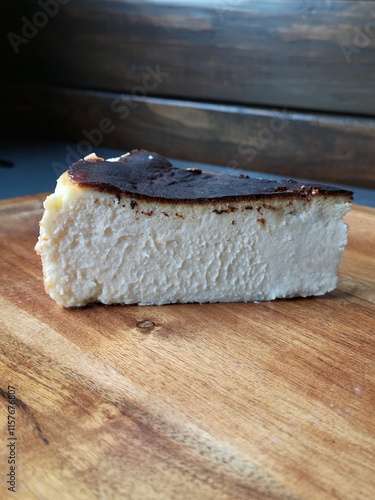 Basque New York style cheesecake slice on wooden plate  photo