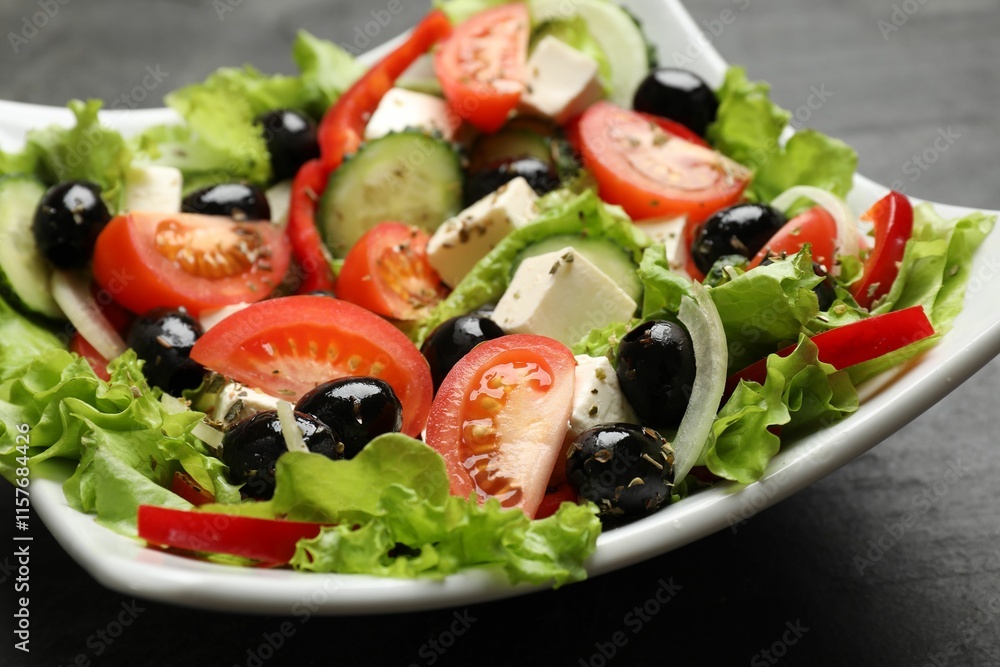 Delicious fresh Greek salad on black table, closeup Delicious fresh Greek salad on black table, closeup