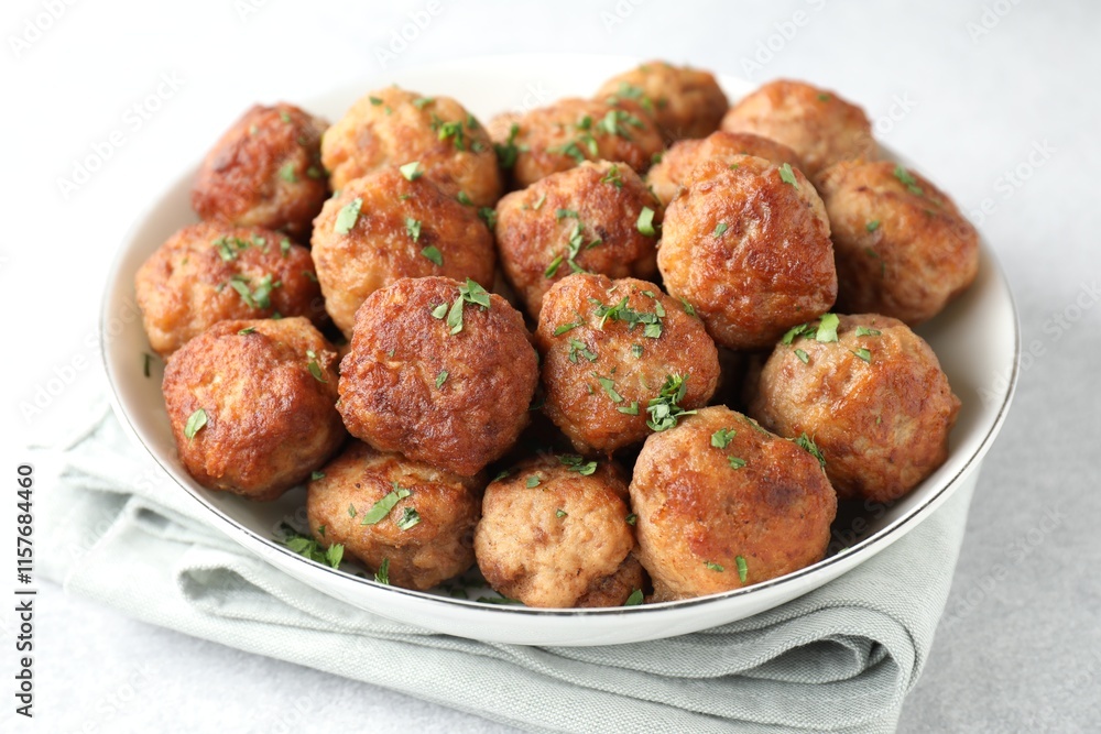 Tasty cooked meatballs with green onion in bowl on white table, closeup Tasty cooked meatballs with green onion in bowl on white table, closeup