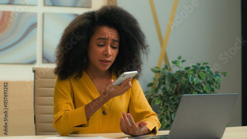 Furious angry mad African American business woman ethnic annoyed female entrepreneur businesswoman talking mobile phone arguing voice message speakerphone stressed girl talk smartphone call in office