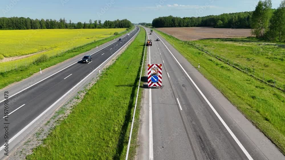 Aerial View of Highway with tractor mowing grass Aerial View of Highway with tractor mowing grass