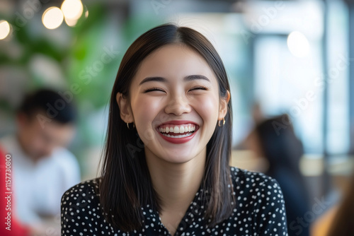 Wallpaper Mural Asian woman with a big smile on her face is wearing a black polka dot shirt. She is surrounded by other people in the background Torontodigital.ca
