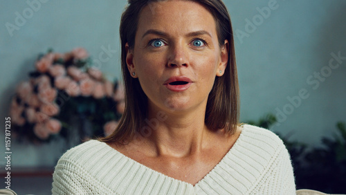 Fotografie Headshot of a surprised woman opening her mouth in amazement and wonder, wearing