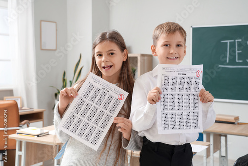 Happy pupils with results of test in classroom photo