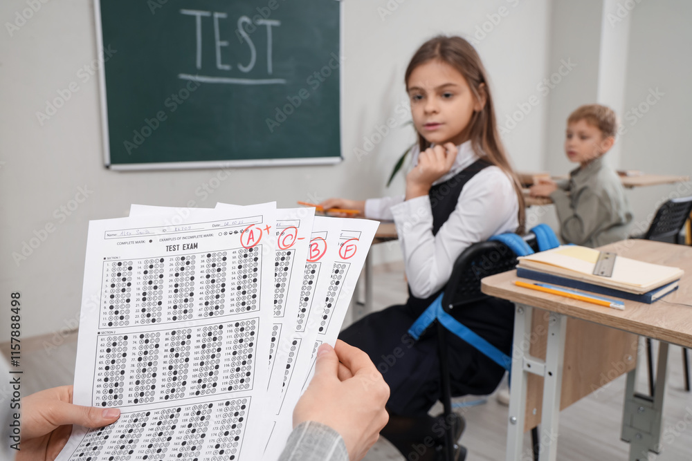 Teacher with checked answer sheets in classroom, closeup Teacher with checked answer sheets in classroom, closeup