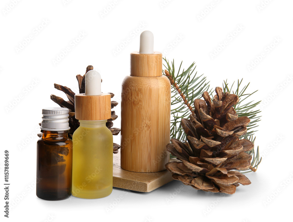 Bottles of essential oil with pine cones and fir branch on white background Bottles of essential oil with pine cones and fir branch on white background