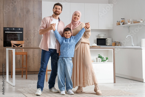 Canvas Print Happy Muslim family holding hands in kitchen