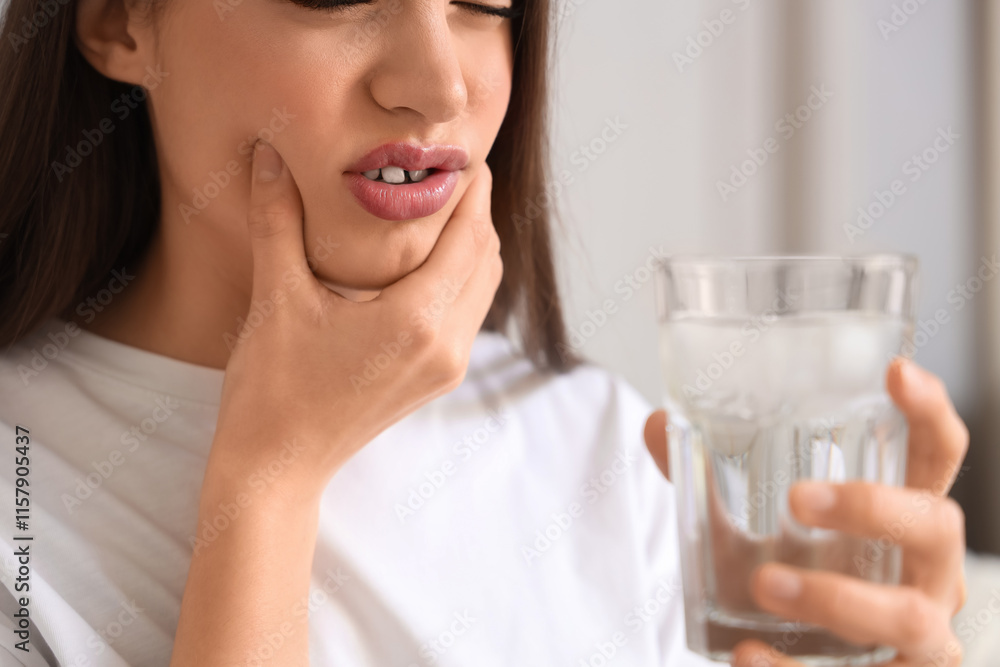 Young woman suffering from toothache with cold water at home, closeup Young woman suffering from toothache with cold water at home, closeup
