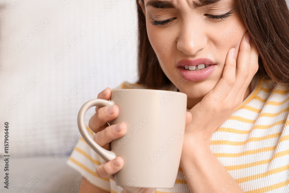 Young woman with cup of coffee suffering from toothache at home, closeup Young woman with cup of coffee suffering from toothache at home, closeup
