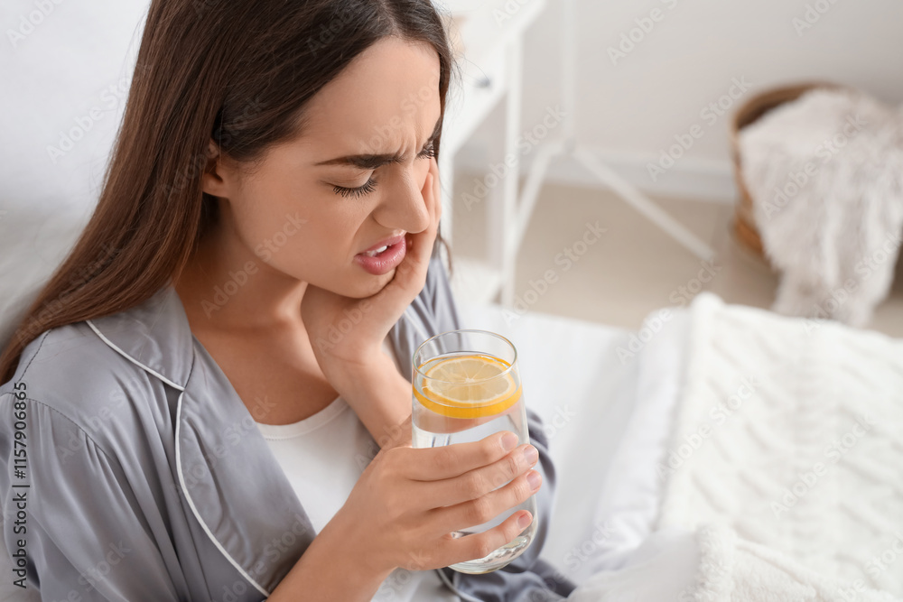 Young woman in pajamas with lemon water suffering from toothache at home, closeup Young woman in pajamas with lemon water suffering from toothache at home, closeup