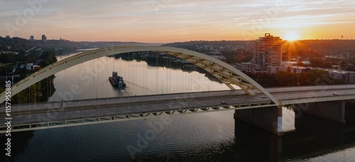 Sunrise over the city, a barge on the river, and the iconic bridge. Beautiful morning light. Daniel Carter Beard Bridge, Cincinnati, Ohio, United States photo