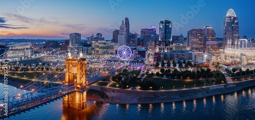 Quadro su tela Cincinnati skyline at twilight, illuminated by city lights reflecting on the river