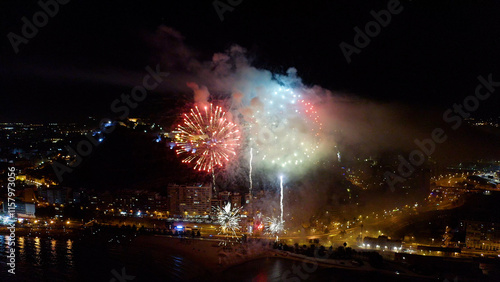 Nocturne aerial view of the fireworks launched in the beach of El Postiguet, in the Mediterranean city of Alicante, Spain. photo