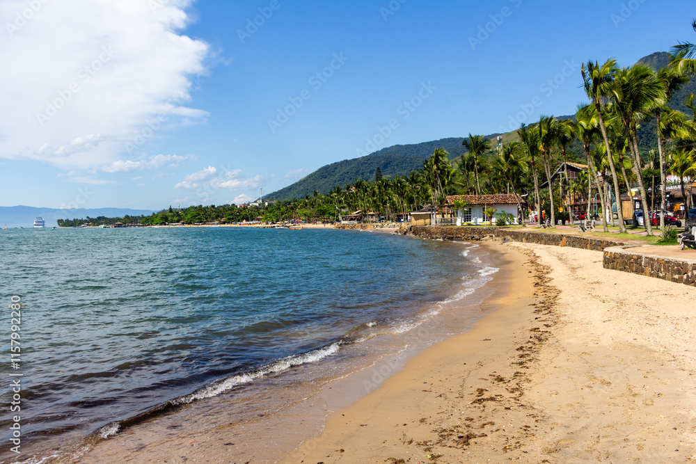 ILHABELA, SP, BRAZIL - DECEMBER 06, 2024: Pereque Beach with a cruise ship in the background and Baepi peak on the right. ILHABELA, SP, BRAZIL - DECEMBER 06, 2024: Pereque Beach with a cruise ship in the background and Baepi peak on the right.