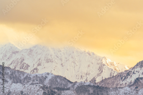 夕日に染まった雲をかぶる八海山