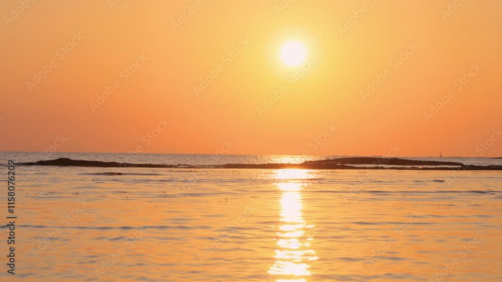 オレンジ色の美しい太陽が水平線に沈む様子 オレンジ色の美しい太陽が水平線に沈む様子