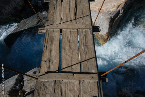 Wooden planks of suspension bridge over Nilgiri River, Annapurnas, Nepal photo