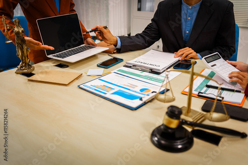 Two male and female lawyers sit at a table in an office, discussing legal matters related to opening a company.They focus on laws, regulations,and collaboration between in-house and business lawyers