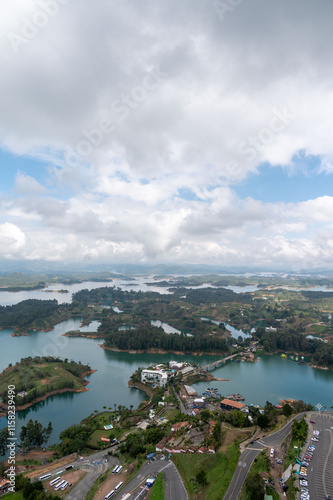Serene islands nestled in a tranquil lake, framed by a picturesque landscape under a partly cloudy sky.