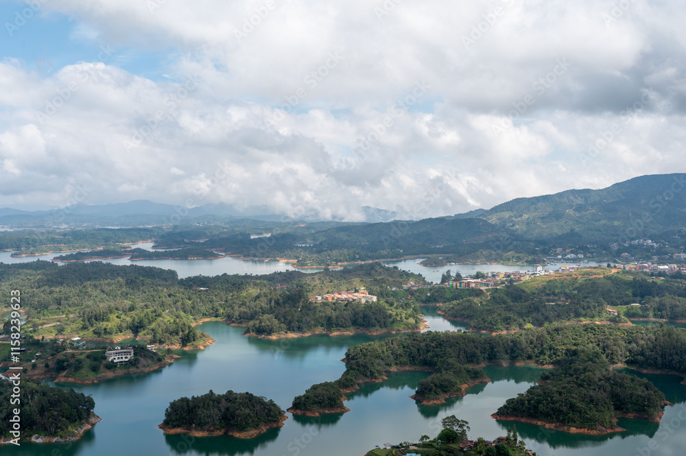 Serene landscape of lush islands nestled in a tranquil lake, framed by majestic mountains under a cloudy sky. Serene landscape of lush islands nestled in a tranquil lake, framed by majestic mountains under a cloudy sky.
