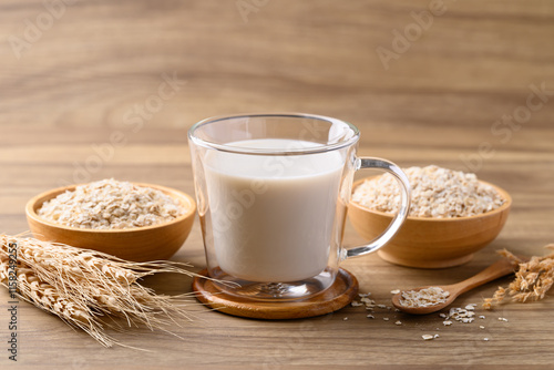 Oat milk in cup glass on wooden background, Alternative milk made from plant, non dairy photo