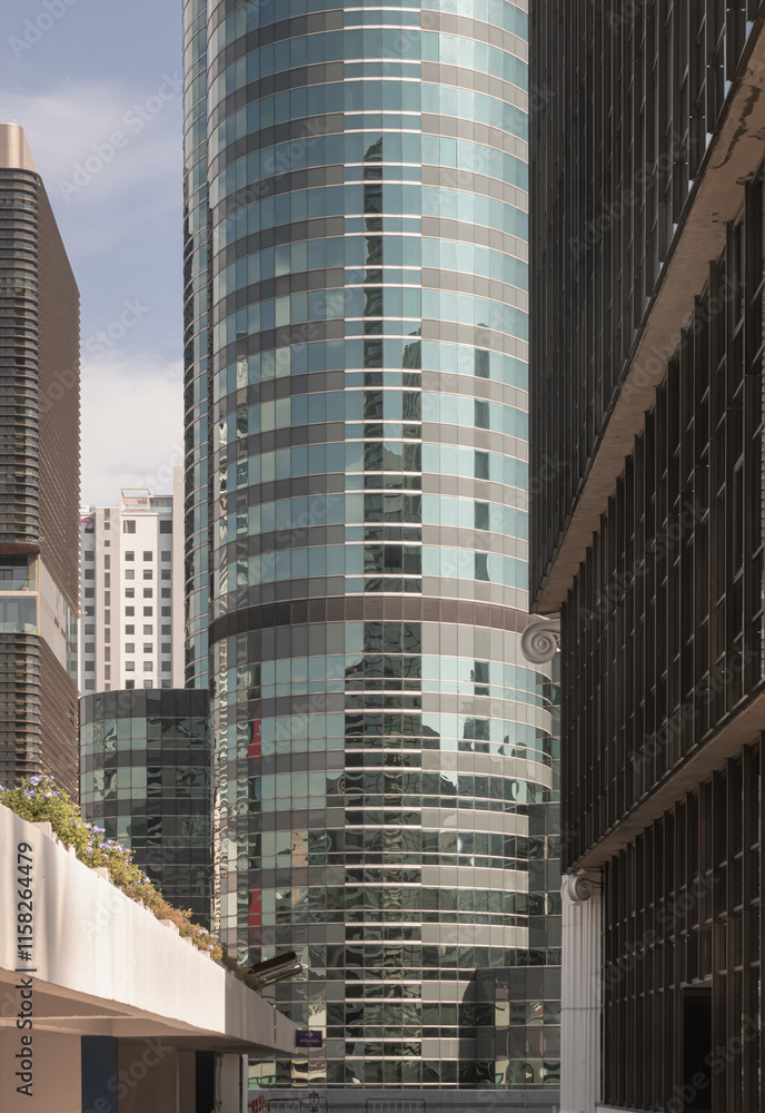 Perspective view of modern building with blue sky reflection in windows glass. Steel frame and glass windows architecture, use it as your Wallpaper, Poster and Space for text, Selective focus.