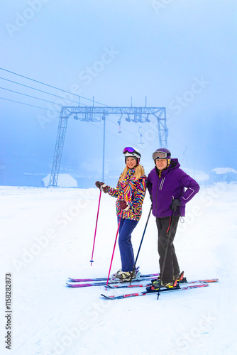 Obraz na płótnie Two father and daughter skiers enjoying a beautiful day on the slopes surrounded by nature and snow w salonie