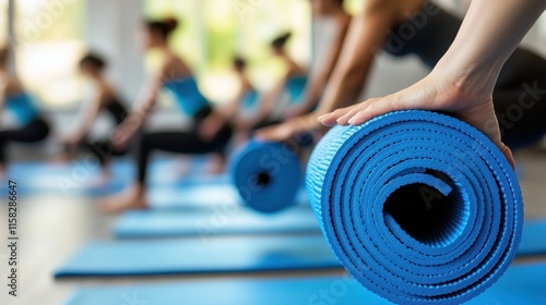 A blue yoga mat is rolled up on the floor