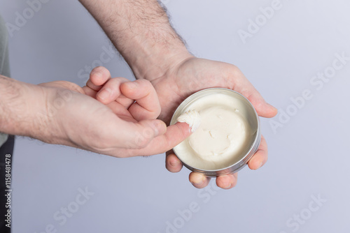 Photos Close-up of male hands holding styling pomade in a round container