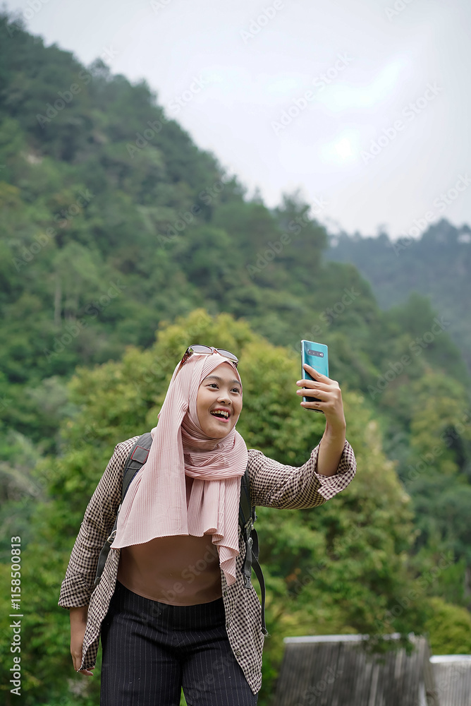 young indonesian female traveler wearing hijab taking photos while traveling in nature, travel concept. young indonesian female traveler wearing hijab taking photos while traveling in nature, travel concept.