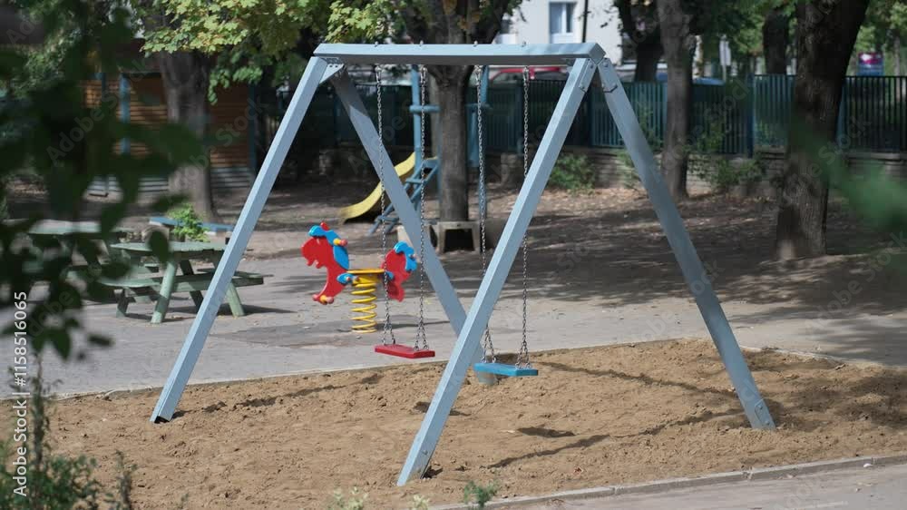 Empty playground with swings and spring rocker in a sunny park Empty playground with swings and spring rocker in a sunny park