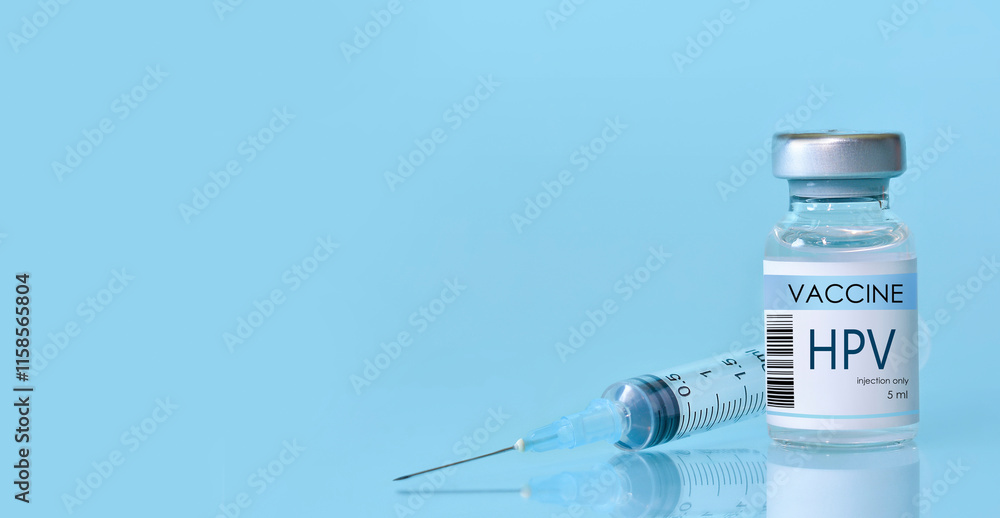 HPV Vaccine in a bottle with a syringe on a blue background. Experimental HPV vaccine vial for immunization against HPV disease. Copy space HPV Vaccine in a bottle with a syringe on a blue background. Experimental HPV vaccine vial for immunization against HPV disease. Copy space