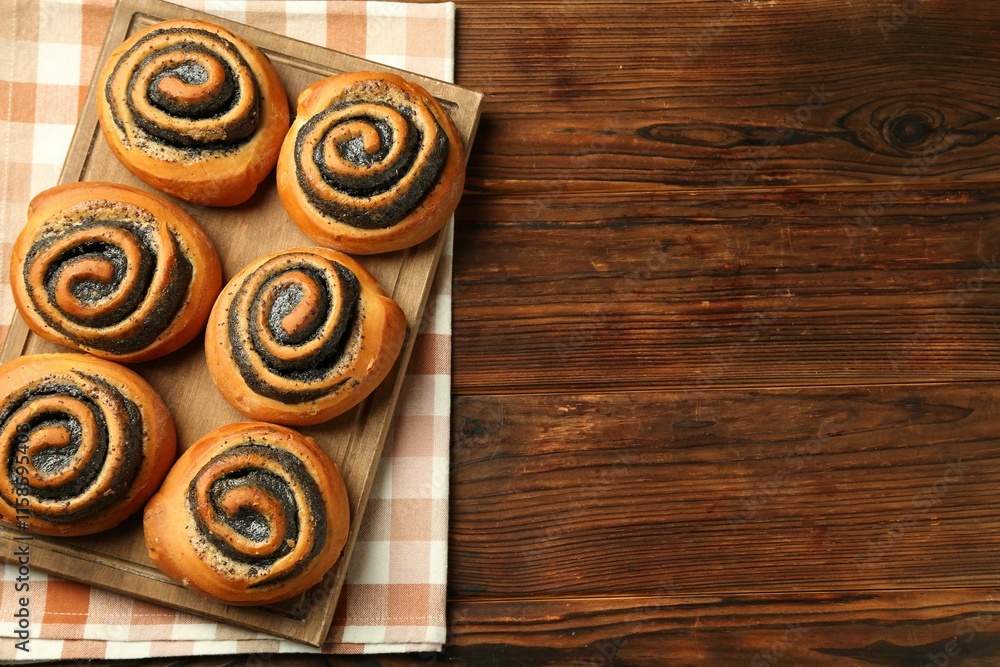 Tasty buns with poppy seeds on wooden table, top view. Space for text Tasty buns with poppy seeds on wooden table, top view. Space for text
