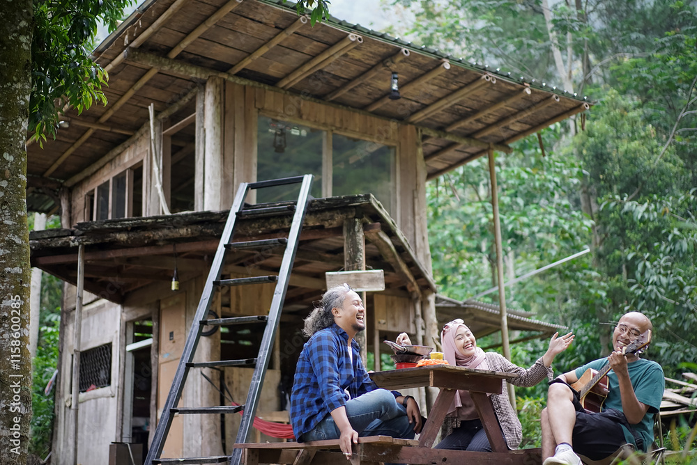 Indonesian man and woman in hijab relaxing in front of forest cabin, travel concept. Indonesian man and woman in hijab relaxing in front of forest cabin, travel concept.