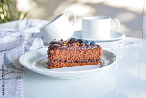 chocolate sacher cake decorated for party. neutral white background with kitchen elements. homemade chocolate cake.