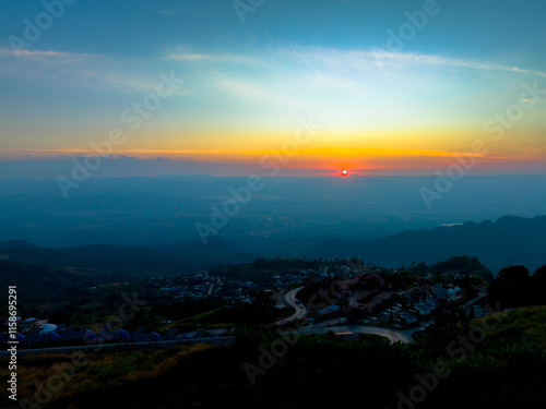 Wallpaper Mural aerial view of a winding mountain road surrounded by lush greenery, scattered houses, and farmland. This scenic landscape captures the natural beauty and human settlement in a mountainous region. Torontodigital.ca