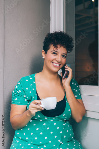 Positive ethnic female chatting on cellphone relaxing in street cafe #1158729650