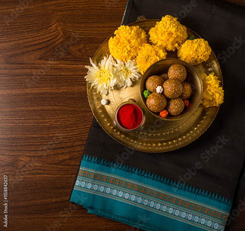 A plate with Tilgul, flowers and Kumkum powder placed with black saari - A tradition to celebrate Indian festival of Makar Sankranti in India. photo