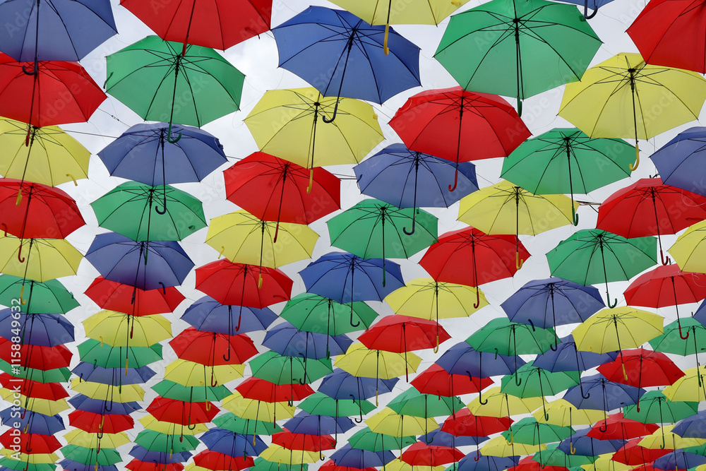 Naklejka premium Paraguas de colores decorando y dando sombra en las calles de los pueblos y ciudades